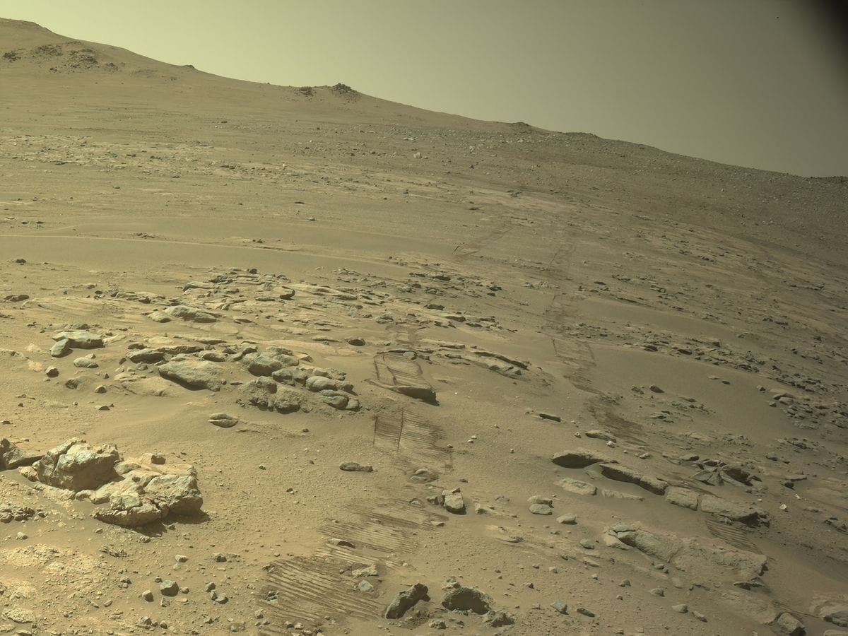 A long trail of tire tracks left across Mars’ dusty surface by a space rover.