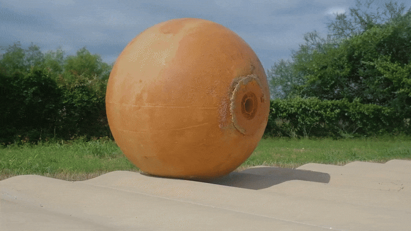 A GIF of a spherical robot rolling over a bumpy path.