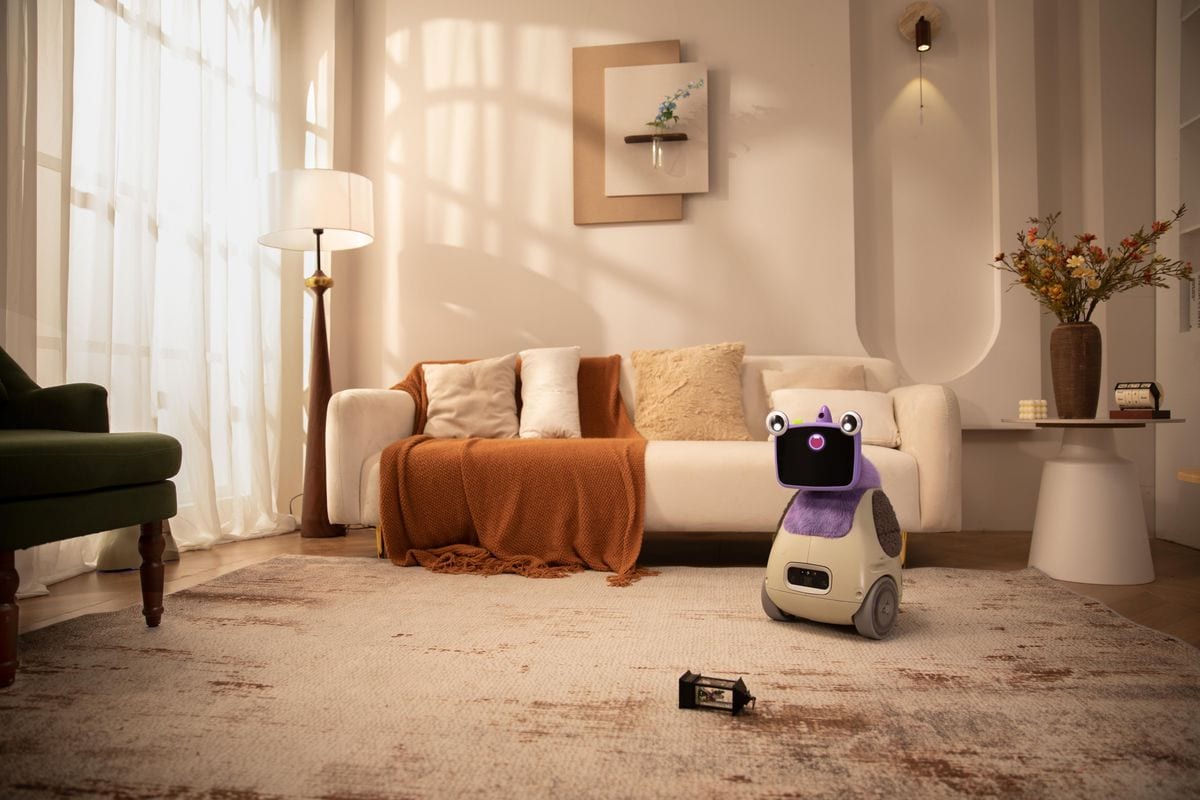Cute home robot on carpet in cozy living room with beige sofa and warm lighting