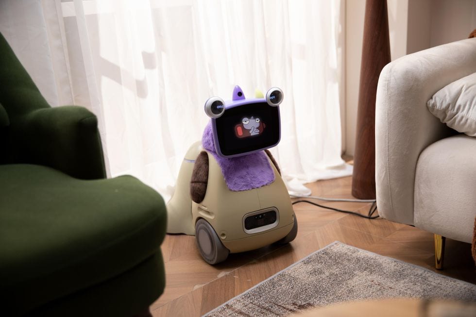 Cute home robot with a purple cover and cartoon face displayed on its screen.