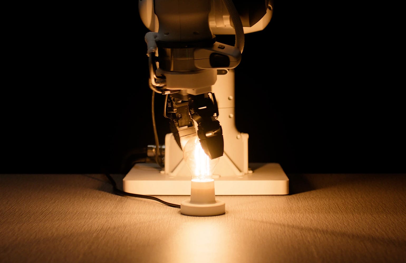 A robotic arm screwing in a lightbulb. Eka Robotics is developing a model to generalize across tasks.